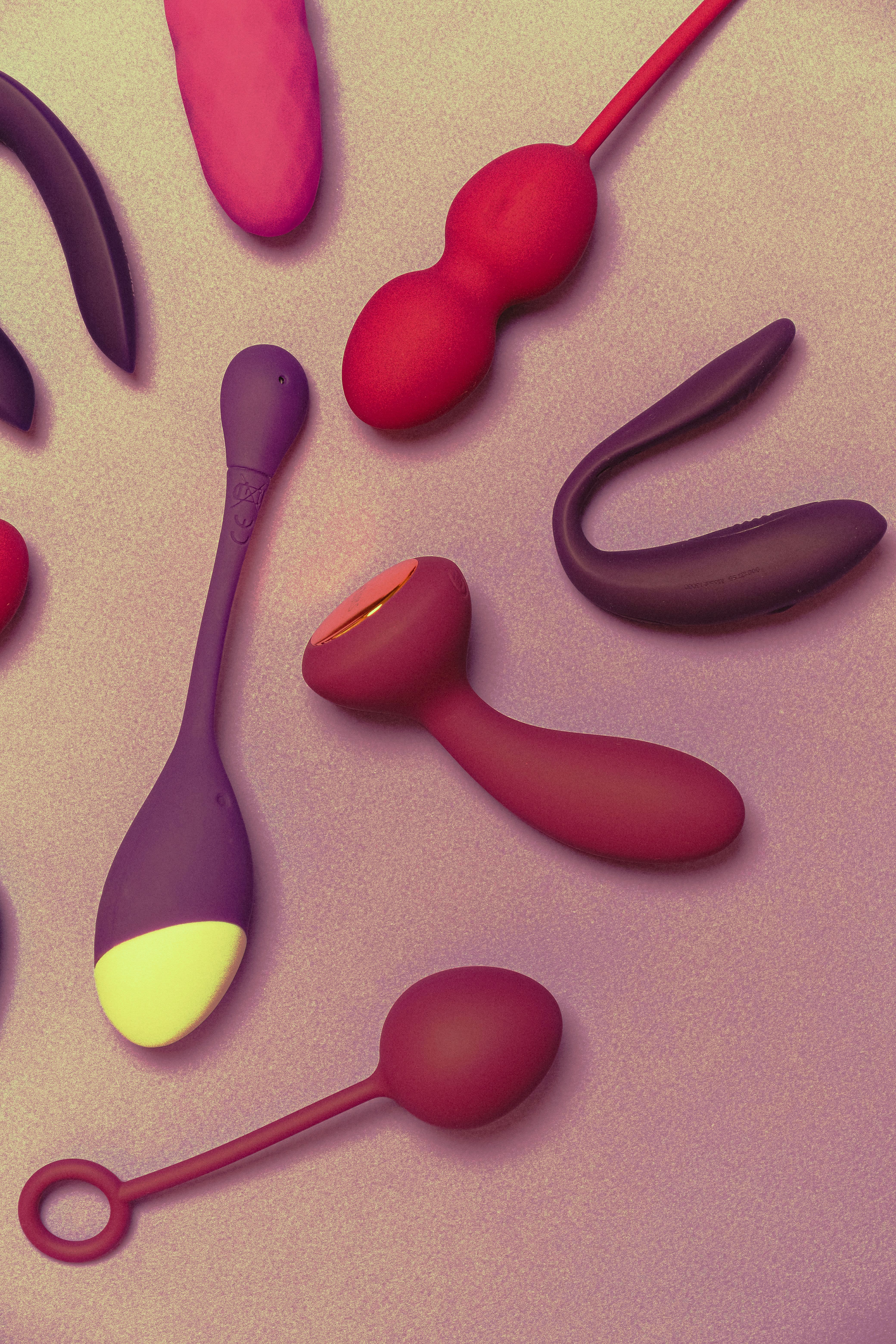 A variety of colorful silicone sex toys on a purple background showcasing modern pleasure products.