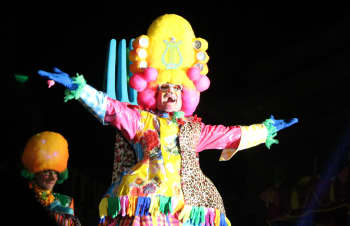 A lively parade with performers in colorful costumes celebrating diversity and pride.
